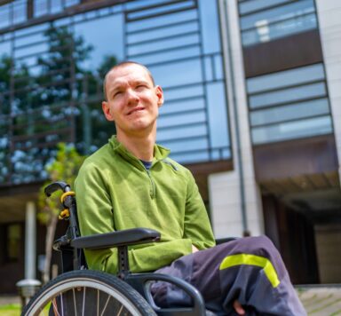 Jongen in rolstoel eet eiwitverrijkte Fijnproevers-maaltijd met zachte structuur, afgestemd op IDDSI-niveaus 3 en 4.